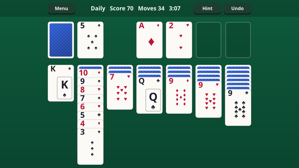 Solitaire: seven columns of cards on green felt, a long run of alternating red and black cards, and the first cards on the foundations.